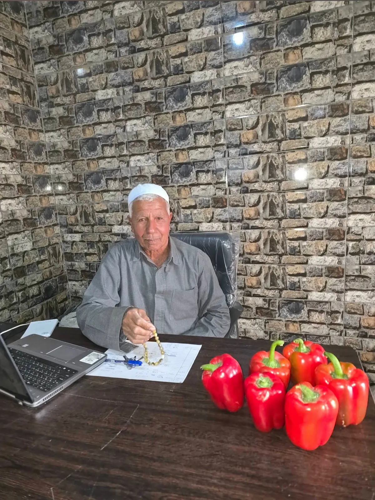 الحاج عزازي قرقر في مكتب المزرعة ومعاه فلفل أحمر